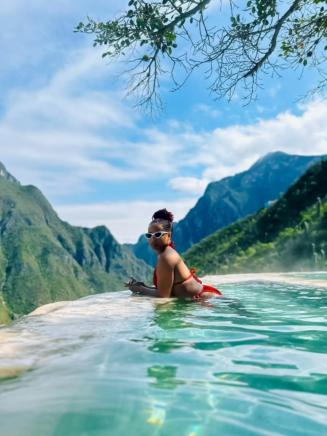 Mujer con lentes disfrutando la poza infinita termal